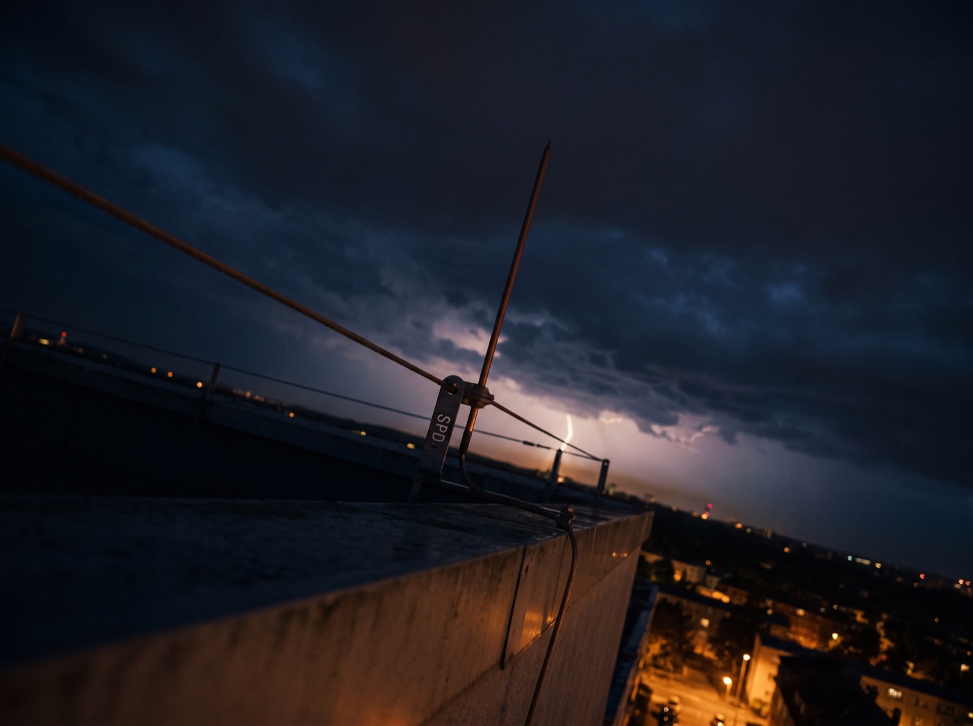 Para-raios no topo de edifício sob céu de tempestade